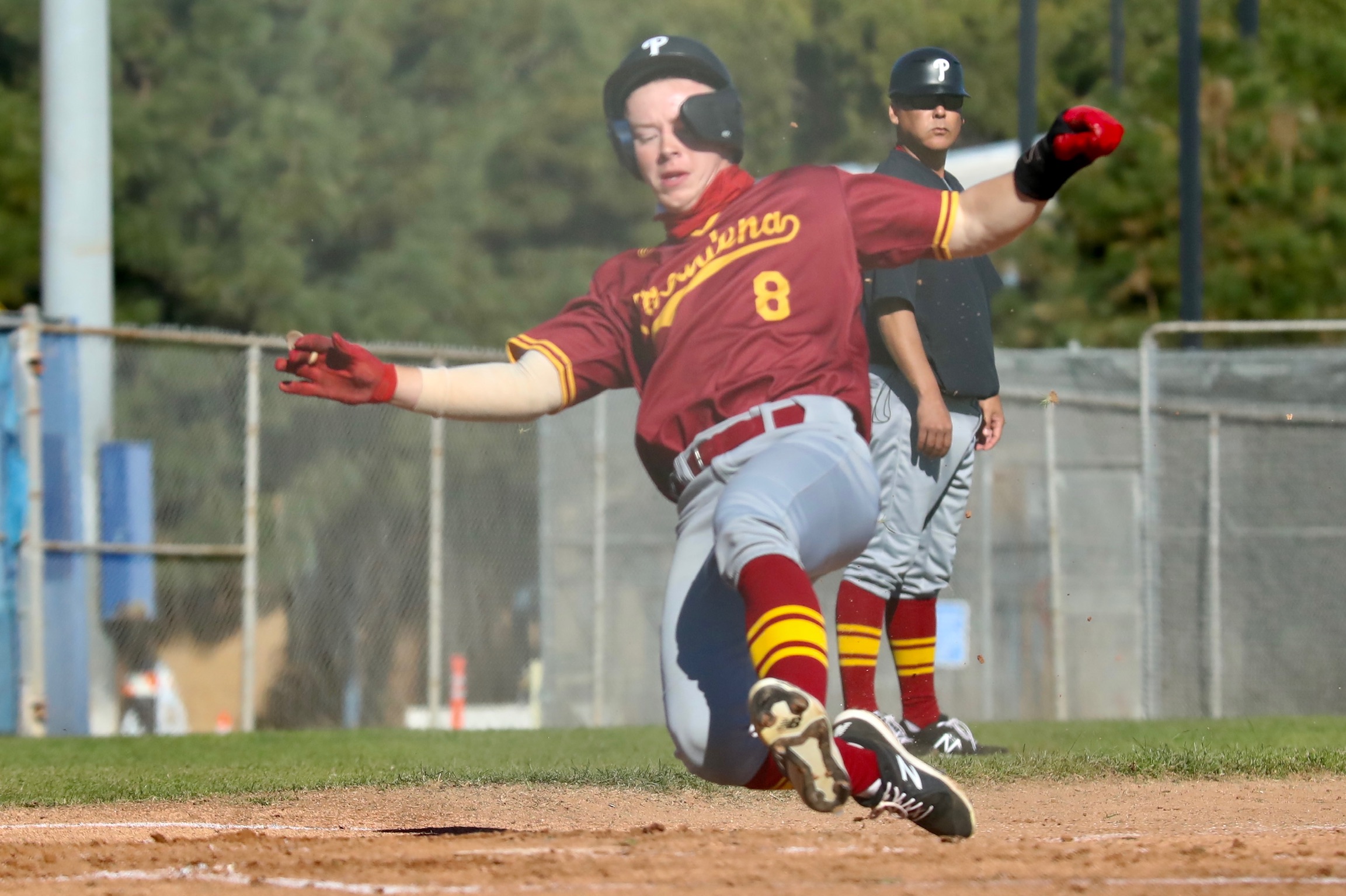 Max Blessinger slides into home during PCC's game on Saturday played at LA Harbor College (photo by Michael Watkins, Athletics).