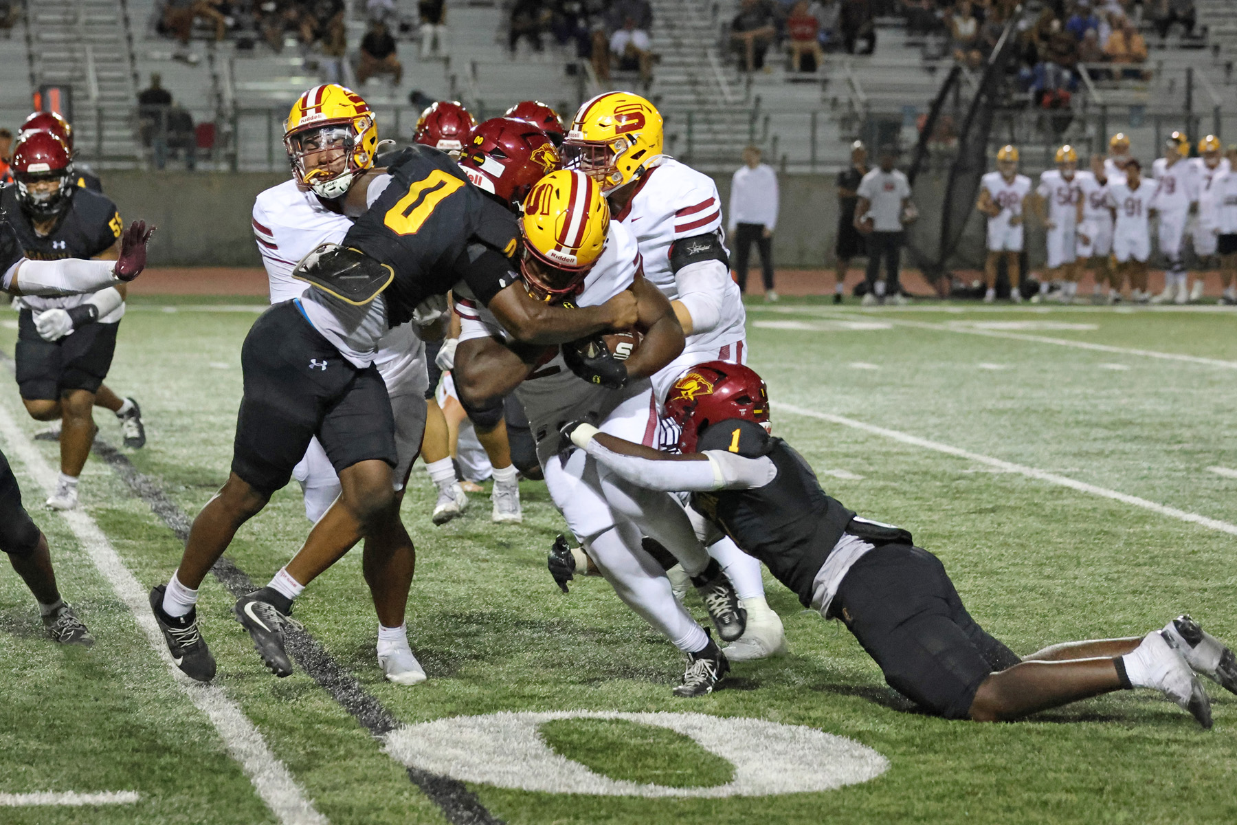 Emmanuel Okelola and Gabriel Sulaiman make the tackle during PCC's season opener on Saturday (photo/gallery by Richard Quinton).